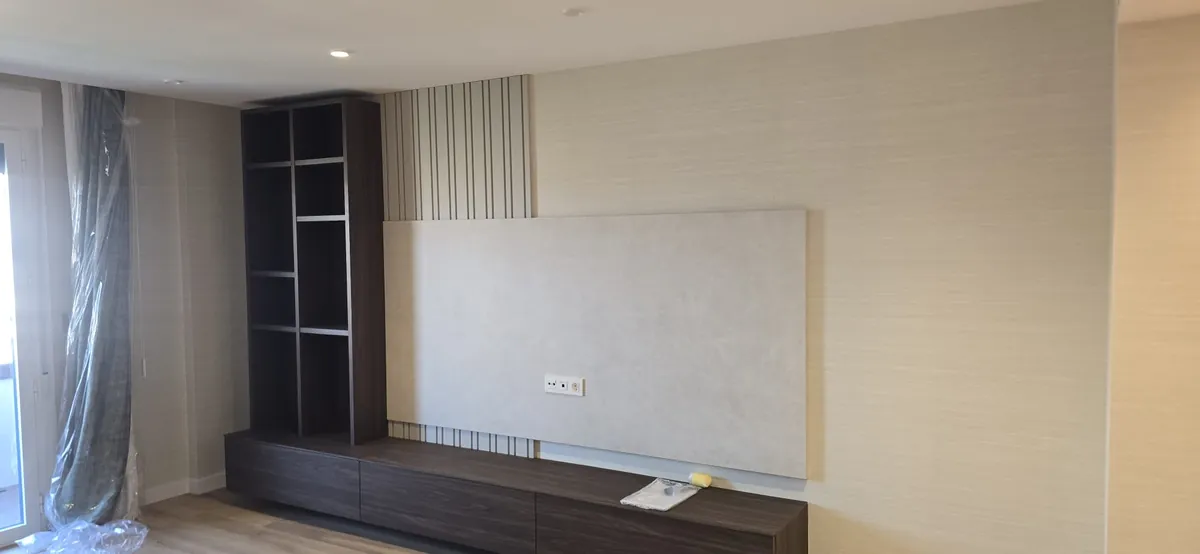 Salón con mueble de televisión y pared con papel pintado de rayas