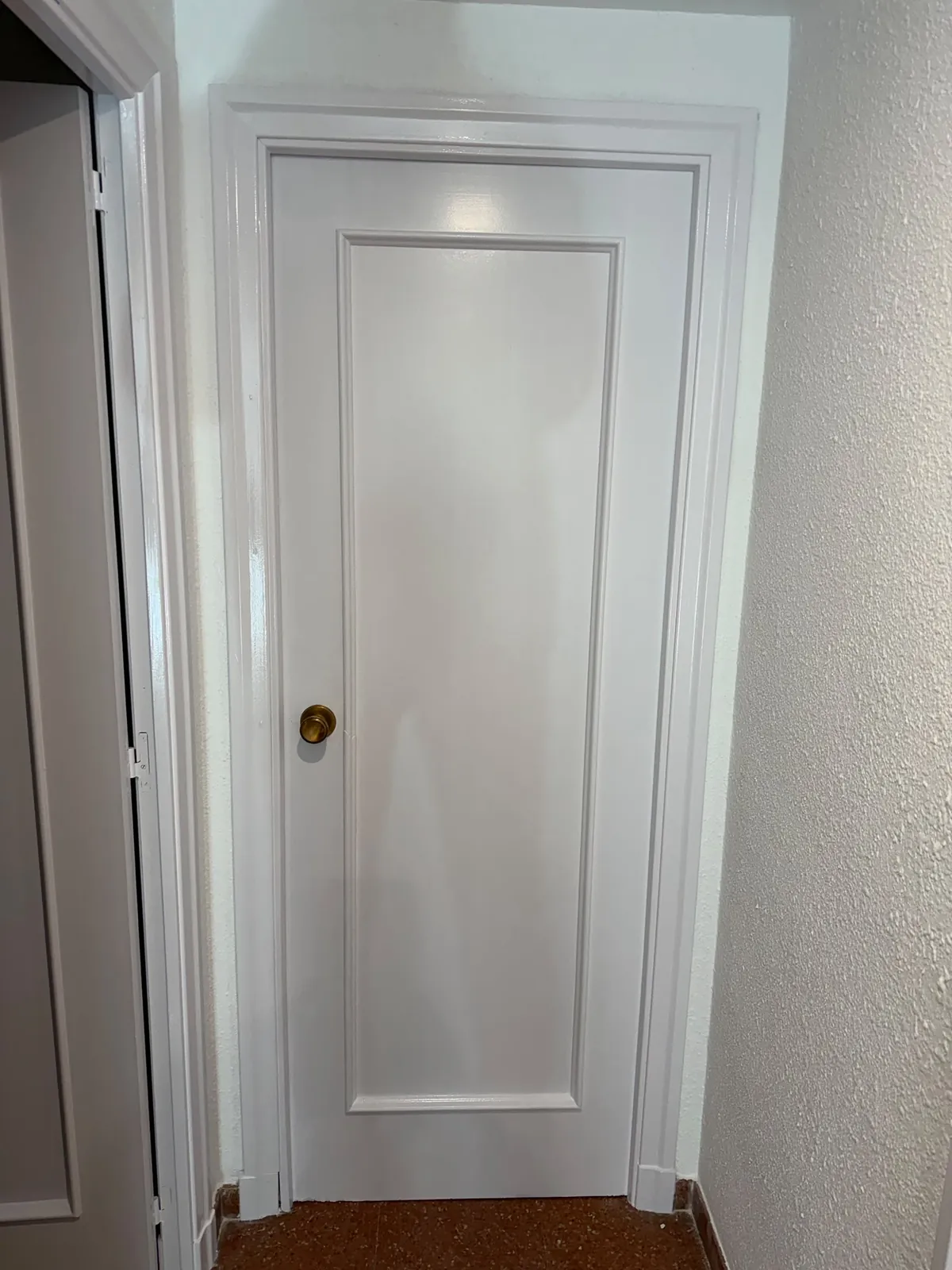 Puerta lacada en blanco con manilla dorada, acabado esmaltado satinado