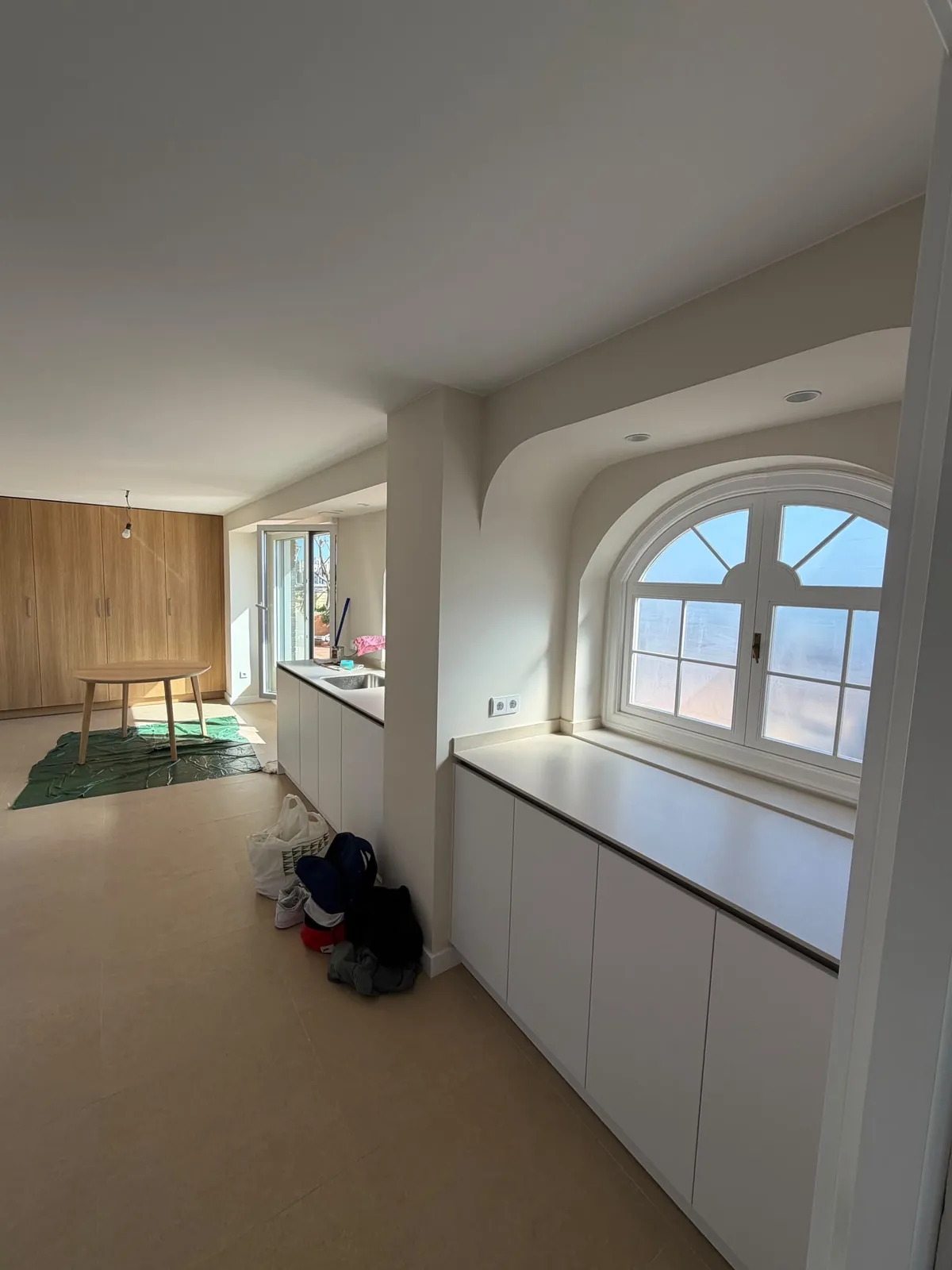 Rincón de cocina con ventana abuhardillada en arco y encimera blanca