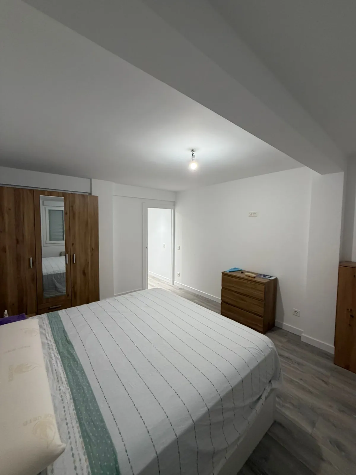 Dormitorio terminado con armario de madera y suelo en tonos grises