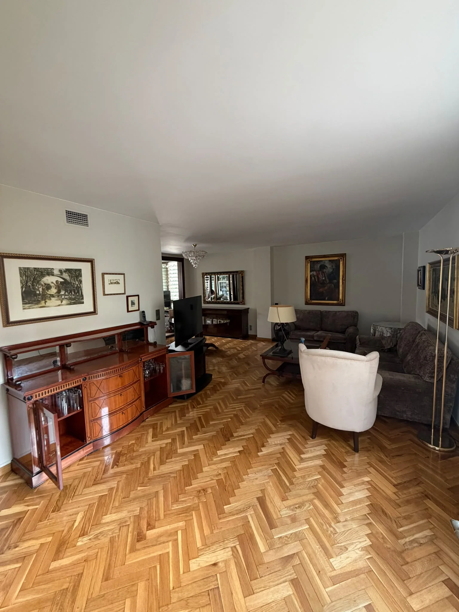 Salón amplio pintado con parquet de espiga