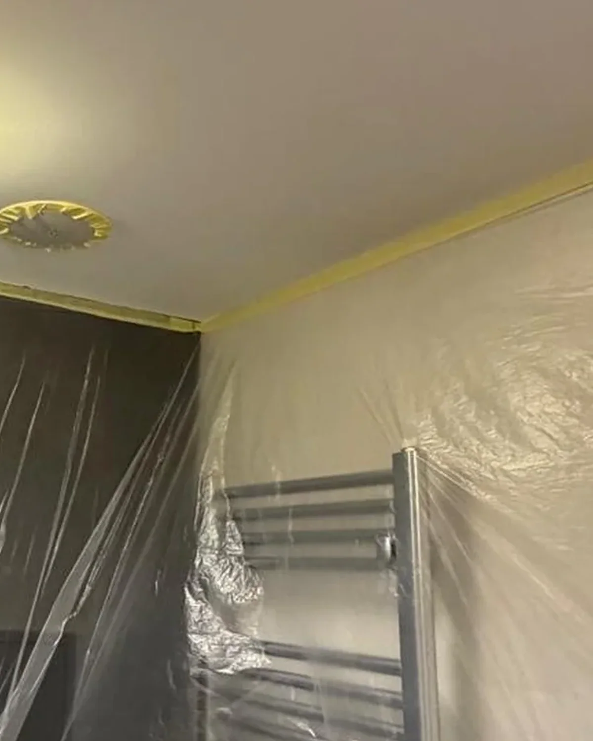 Salón de una vivienda de Zaragoza con el suelo cubierto y los muebles protegidos antes de pintar