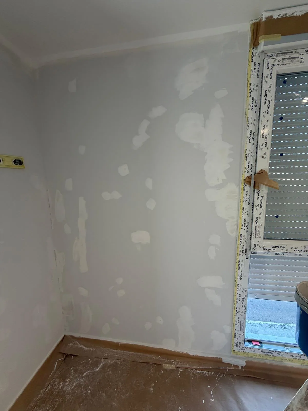 Dormitorio con la pared plastecida y la ventana protegida