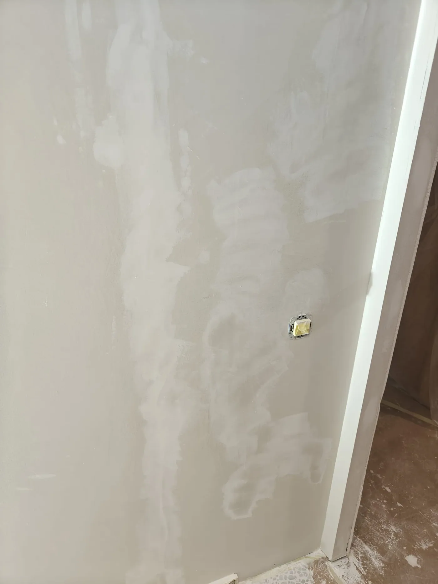 Pared plastecida y lijada con el mecanismo eléctrico desmontado